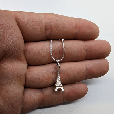 Eiffel Tower Silver Necklace Displayed on a Hand